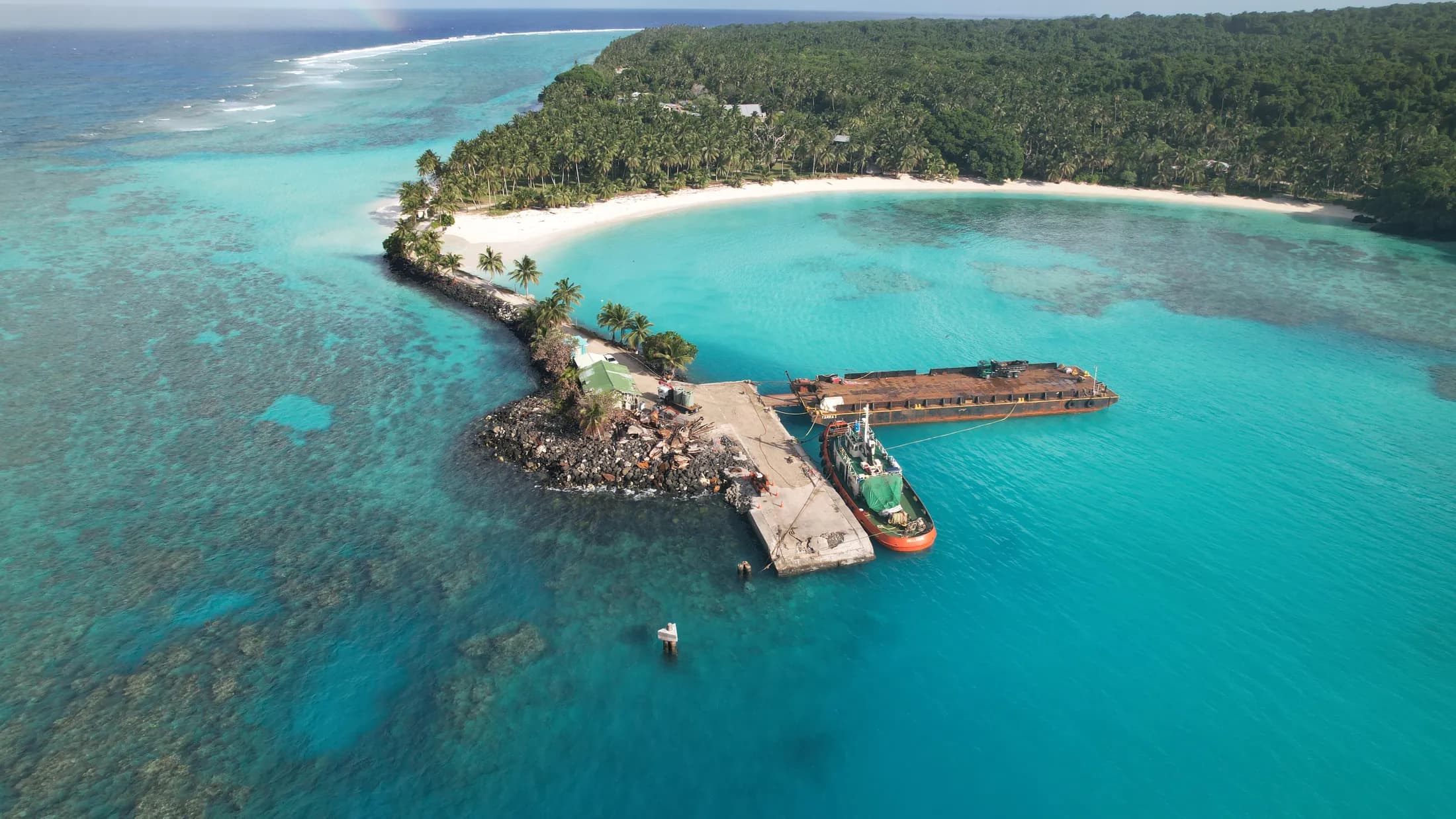 Aerial view of an island jetty over turquoise reef by Croome Photography
